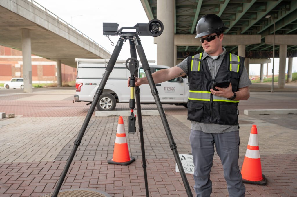 Operator lowering the TREKK360 camera into a manhole from the surface