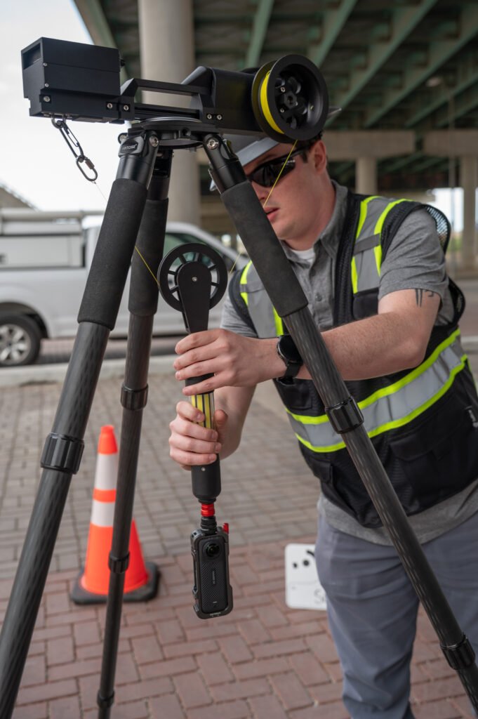 Operator setting up the TREKK360 tripod under an overpass